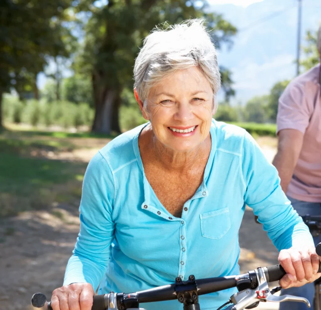 happy senior woman riding a bike without glasses