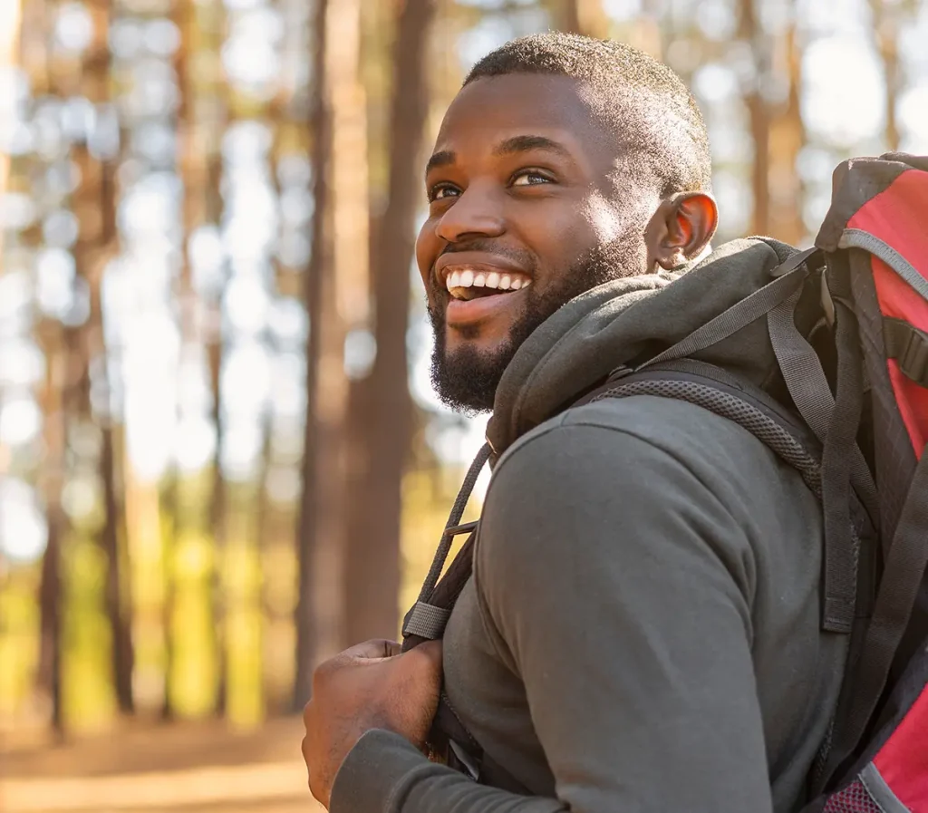 happy young male hiking in the woods without dry eyes