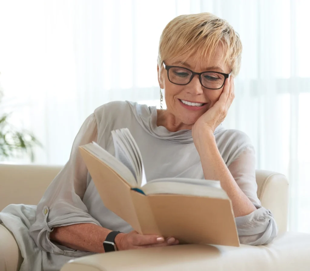 senior woman reading a book while wearing glasses